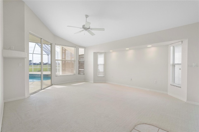 carpeted spare room featuring vaulted ceiling, ceiling fan, and plenty of natural light