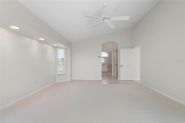 carpeted empty room with ceiling fan and lofted ceiling