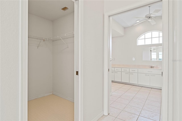 walk in closet with ceiling fan and light tile patterned floors