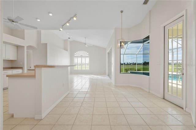 interior space with light tile patterned floors, track lighting, and vaulted ceiling