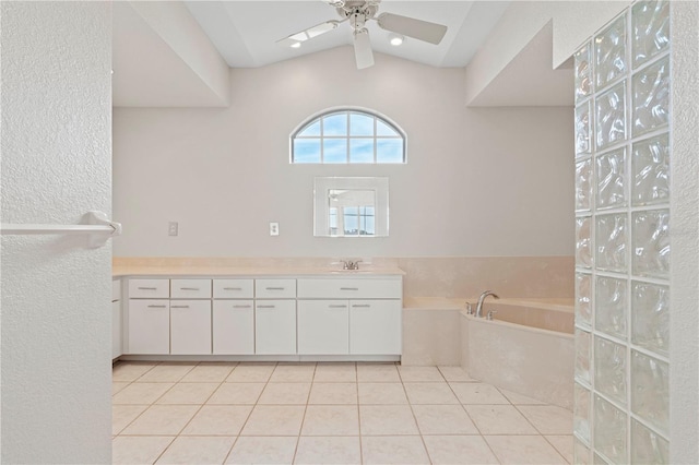 bathroom with ceiling fan, tile patterned flooring, vanity, and lofted ceiling