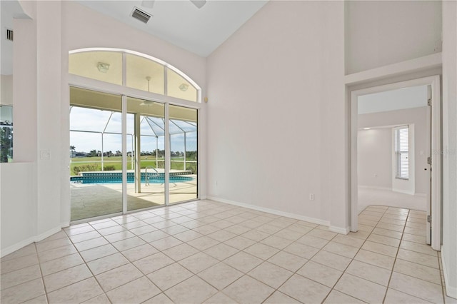 tiled empty room with ceiling fan and lofted ceiling