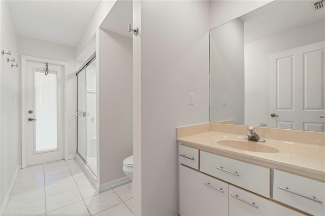 bathroom with tile patterned flooring, vanity, an enclosed shower, and toilet