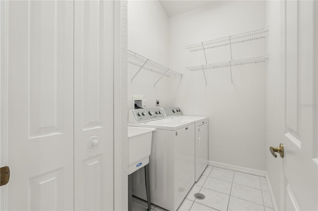 laundry room with washer and clothes dryer and light tile patterned floors