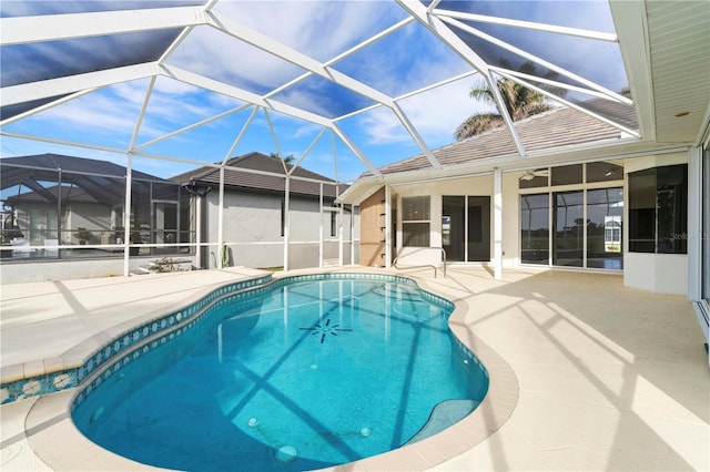 view of pool with glass enclosure, ceiling fan, and a patio