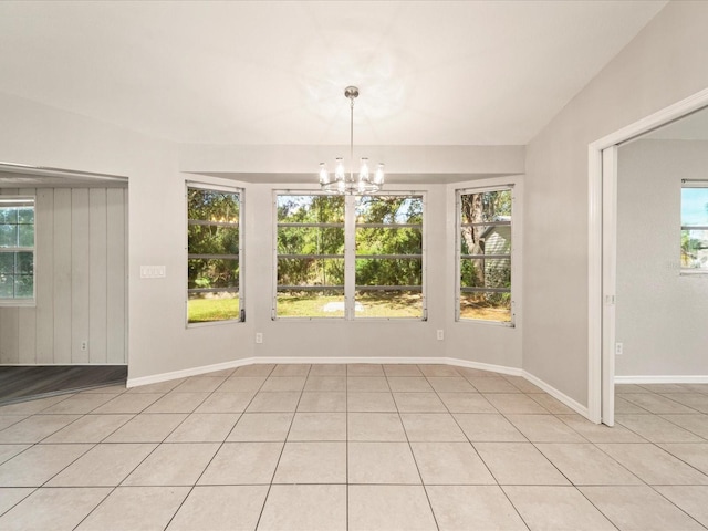 spare room with light tile flooring and a notable chandelier