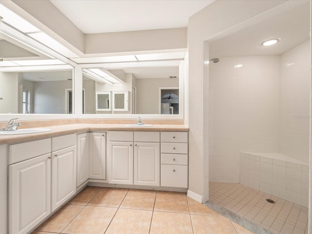 bathroom with dual bowl vanity, tile flooring, and a tile shower