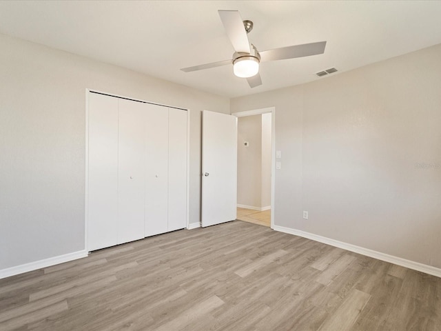 unfurnished bedroom featuring a closet, ceiling fan, and light wood-type flooring