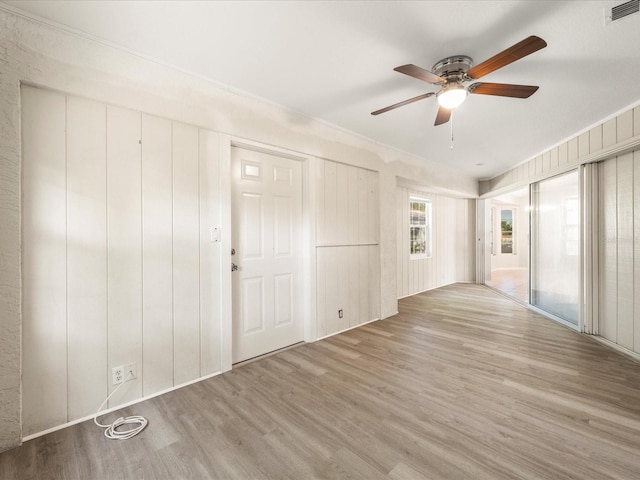 spare room with ornamental molding, ceiling fan, and light hardwood / wood-style flooring