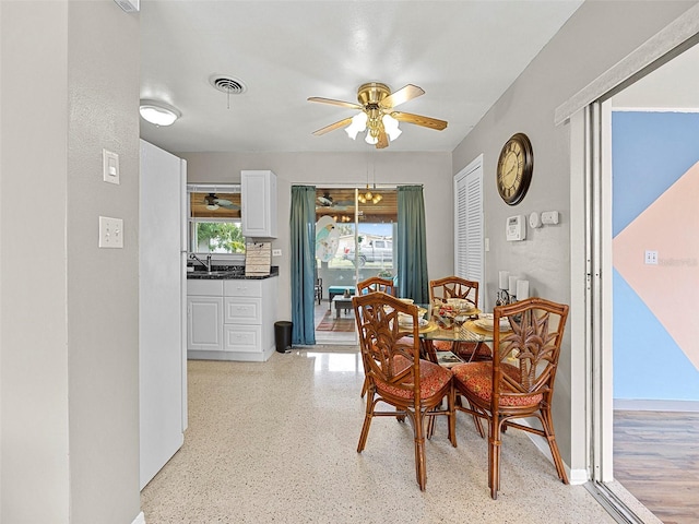 dining space with ceiling fan and sink