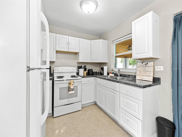 kitchen with white appliances, white cabinets, dark stone counters, and sink