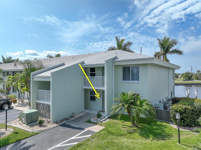 3600 Bal Harbor Blvd Unit 1G, Punta Gorda, FL 33950 - view of front of house featuring a balcony, metal roof, a standing seam roof, a front lawn, and stucco siding