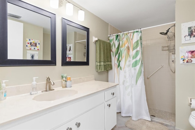 bathroom featuring toilet, vanity, and a shower with shower curtain