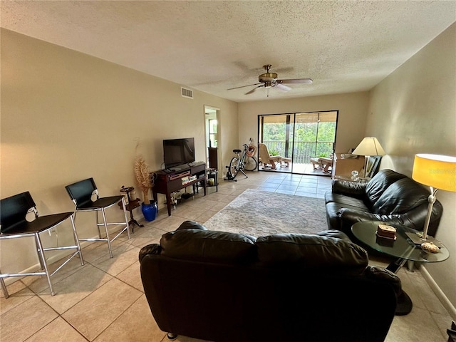 tiled living room featuring ceiling fan and a textured ceiling