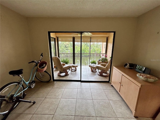 doorway to outside featuring light tile patterned floors and a textured ceiling