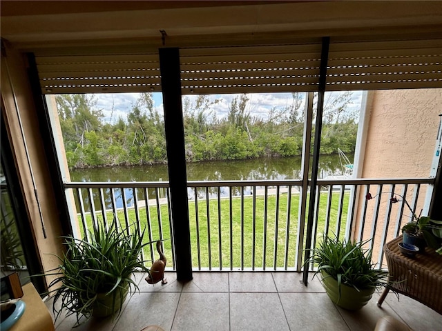 sunroom featuring a water view