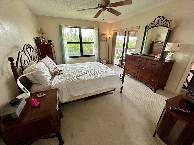 bedroom with ceiling fan, light colored carpet, a textured ceiling, and access to outside