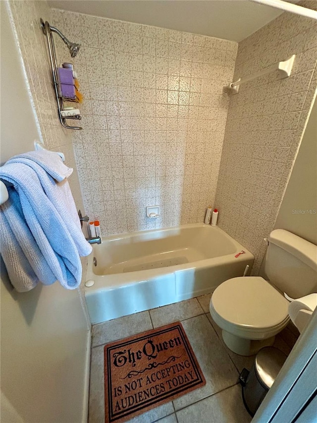 bathroom featuring tile patterned flooring, tiled shower / bath combo, and toilet