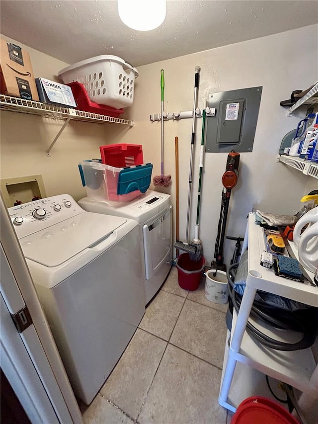 laundry area with washing machine and clothes dryer, electric panel, and light tile patterned floors