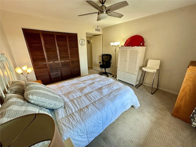 carpeted bedroom featuring ceiling fan and a closet