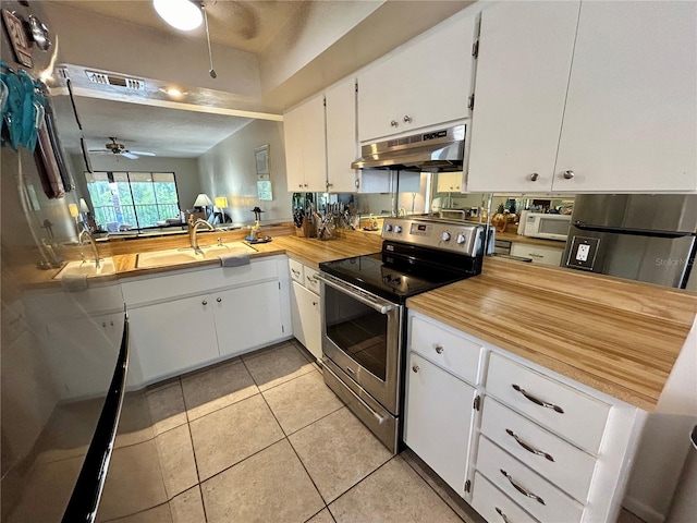 kitchen with appliances with stainless steel finishes, a textured ceiling, ceiling fan, light tile patterned floors, and white cabinetry