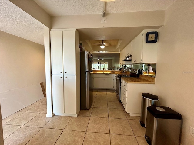 kitchen featuring white cabinets, light tile patterned floors, stainless steel appliances, and sink