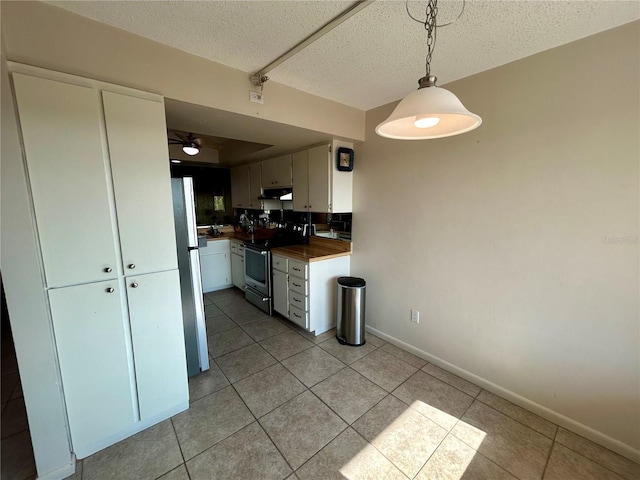 kitchen with refrigerator, a textured ceiling, decorative light fixtures, stainless steel electric range oven, and light tile patterned flooring