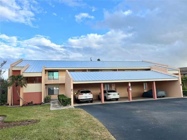 view of front of property featuring a carport and a front lawn