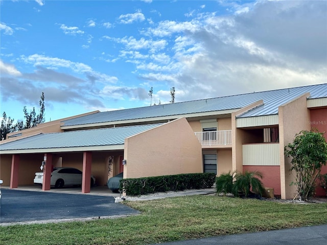 1354 Rock Dove Ct Unit A202, Punta Gorda, FL 33950 - view of front facade with stucco siding, metal roof, a front lawn, and a standing seam roof