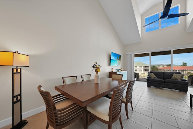 tiled dining space featuring high vaulted ceiling