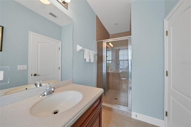 bathroom featuring a shower with shower door, vanity with extensive cabinet space, and tile flooring