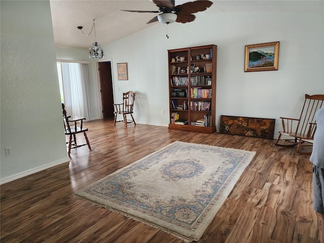 living area featuring lofted ceiling, ceiling fan with notable chandelier, a textured ceiling, and dark hardwood / wood-style flooring