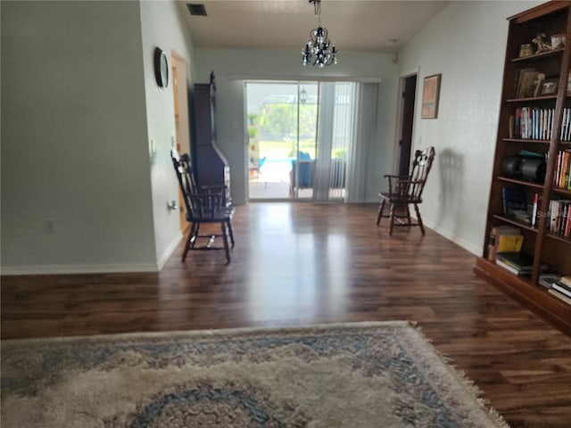 living area with an inviting chandelier and dark hardwood / wood-style flooring