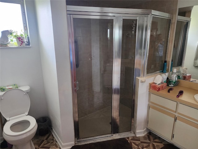 bathroom with vanity, a shower with shower door, parquet floors, and toilet