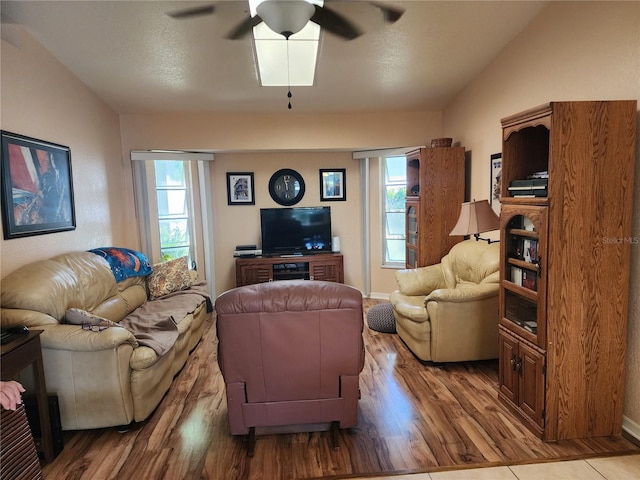 living room with wood-type flooring, ceiling fan, and vaulted ceiling