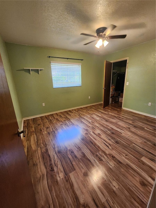 spare room featuring ceiling fan, a textured ceiling, and dark wood-type flooring