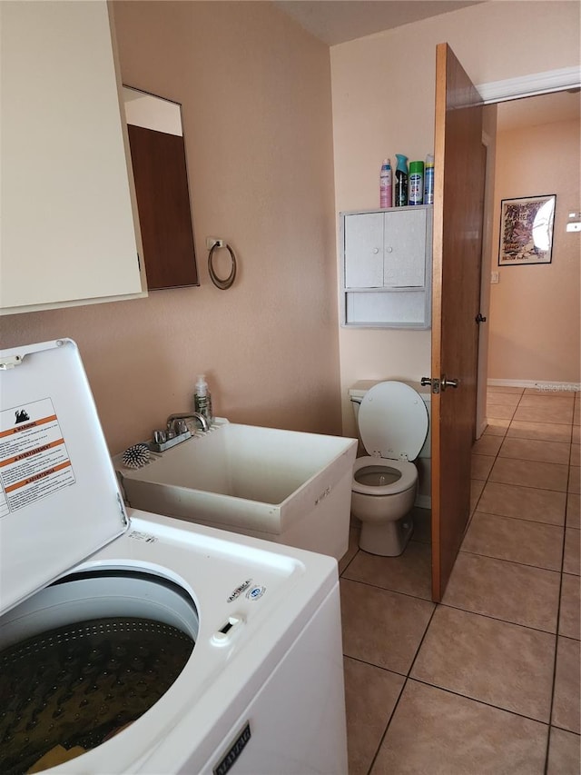 laundry room featuring light tile flooring, washer / dryer, and sink