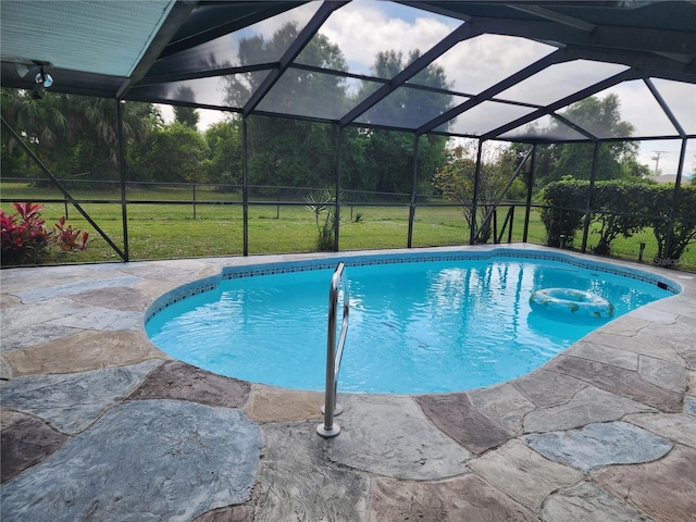 view of swimming pool with glass enclosure, a yard, and a patio