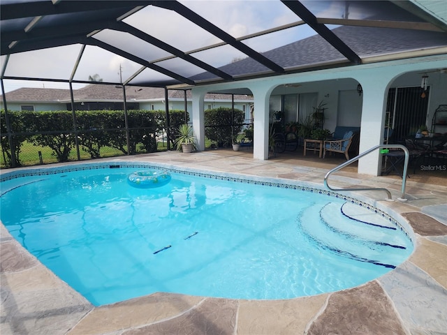 view of swimming pool with glass enclosure and a patio