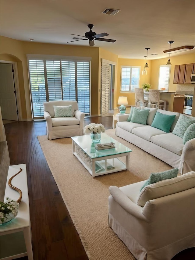 living room featuring ceiling fan and dark hardwood / wood-style flooring