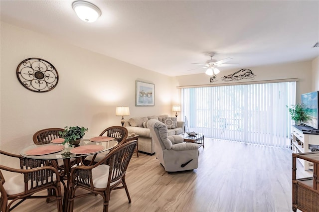 dining area with light hardwood / wood-style floors and ceiling fan