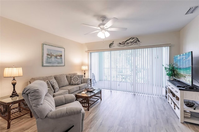 living room featuring light hardwood / wood-style flooring and ceiling fan