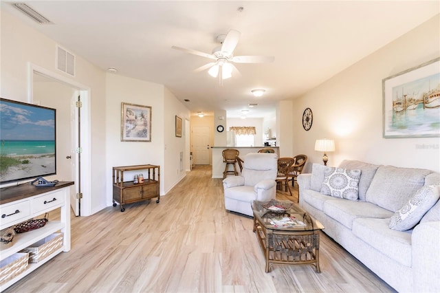 living room with light hardwood / wood-style floors and ceiling fan