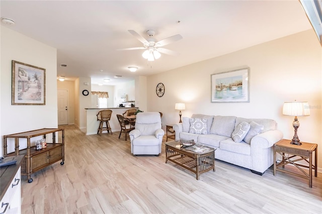 living room featuring ceiling fan and light wood-type flooring