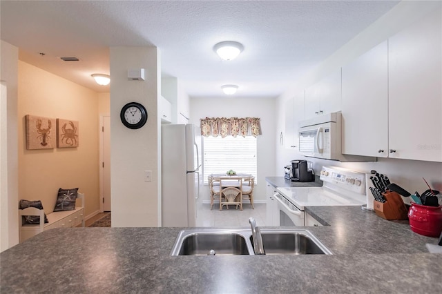 kitchen with white cabinets, white appliances, and sink