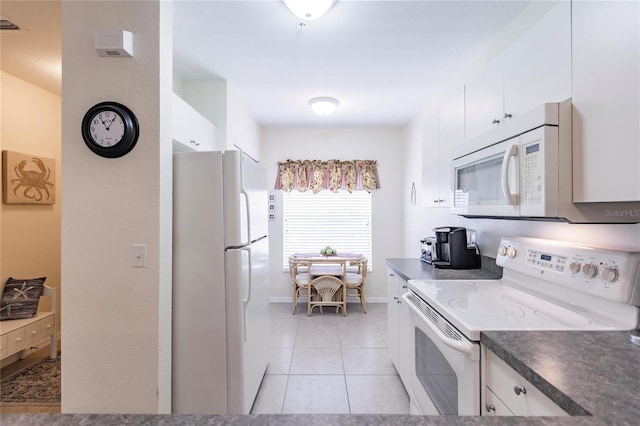 kitchen with white appliances, light tile floors, and white cabinetry