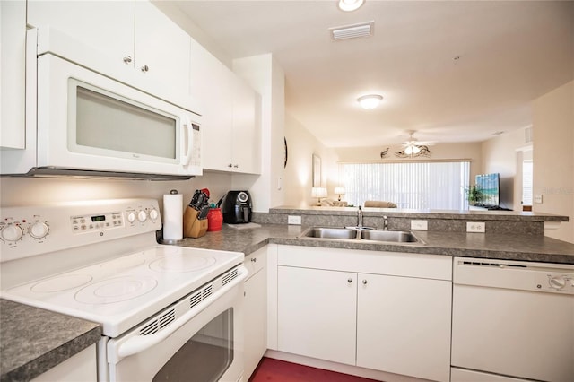 kitchen with kitchen peninsula, white appliances, ceiling fan, white cabinets, and sink