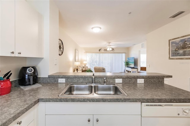 kitchen featuring sink, kitchen peninsula, white cabinetry, and white dishwasher