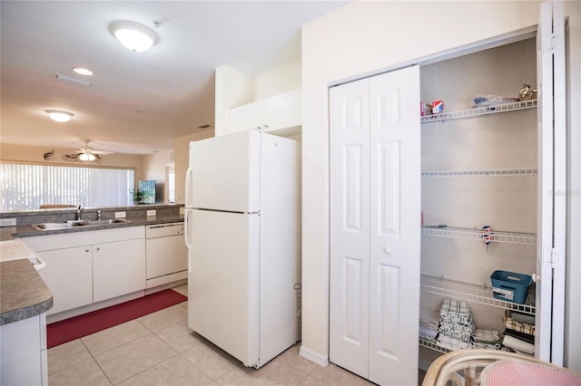 kitchen featuring ceiling fan, light tile floors, sink, white appliances, and white cabinetry