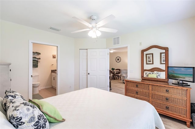 bedroom featuring a closet, light hardwood / wood-style flooring, ceiling fan, and connected bathroom